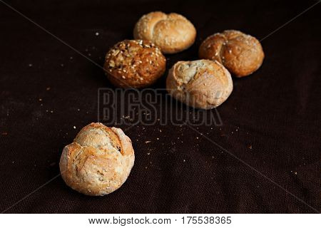 variety of small breads with seeds on black background