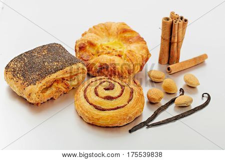 Assortment of baked bread and wheat on table background, homemade bakery, almond, cinamon and vanilla