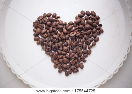 Coffee Beans In Form Of Heart On Beautifull Background. Love. Insparation. On White Plate.
