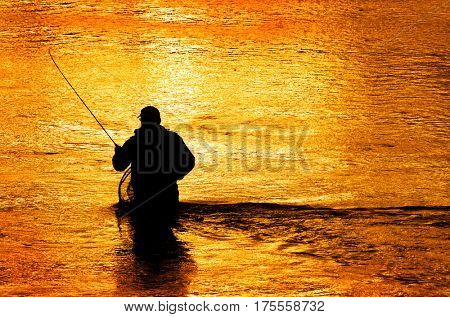 Silhouette of Man Flyfishing Fishing in River
