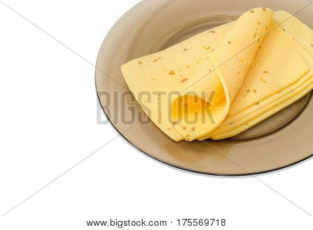 Fragment of the sliced semi-hard cheese made with the addition of the crushed walnuts on a dark glass dish closeup on a light background