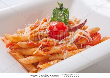 Penne Pasta With Tomato Sauce Sprinkled With Parmesan Cheese In A Deep White Plate