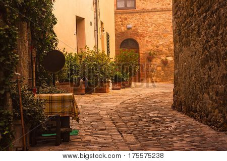 Empty street of small Tuscany town San Quirico d'Orcia in the morning fog, romantic travel vintage hipster european italy background