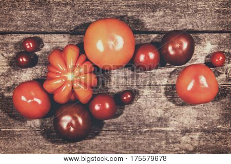 various tomatoes on a rustic wooden background