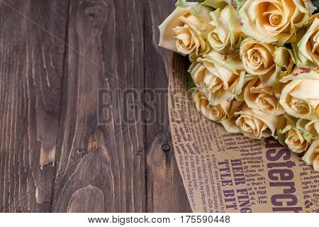 Many natural beige roses background on a wooden table.
