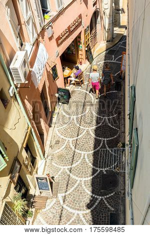 Antibes, France - June 27, 2016: day view of old town street with tourists in Antibes France. Antibes is a popular seaside town in the heart of the C