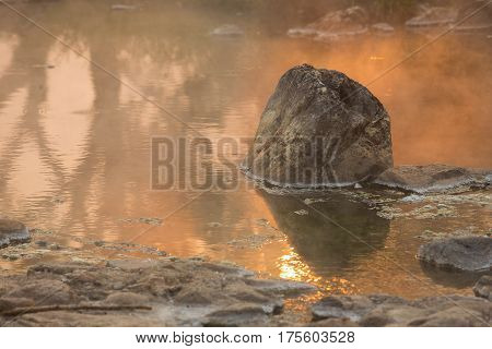 Sun reflecing on the Hot spring at national park during sunrise Thailand
