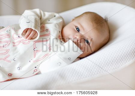 Cute adorable newborn baby againgst white background. New born child, little girl looking surprised at the camera. Family, new life, childhood, beginning concept.