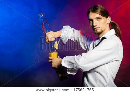 Flair bartending alcohol liquor party concept. Barman showing his skills. Young male tapster makes cocktail.