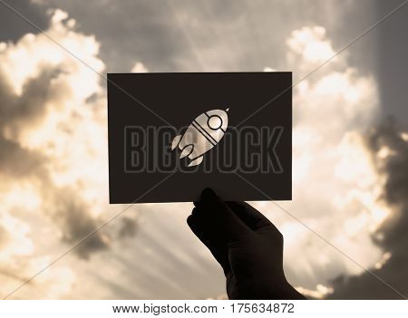 Hand Hold Space Rocket Paper Carving with Sky Background