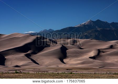 Contrast between the solid rock mountains and the drifting sands in the Great Sand Dunes National Park in southern Colorado near Alamosa