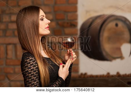 Woman Tasting Wine In Rural Cottage Interior