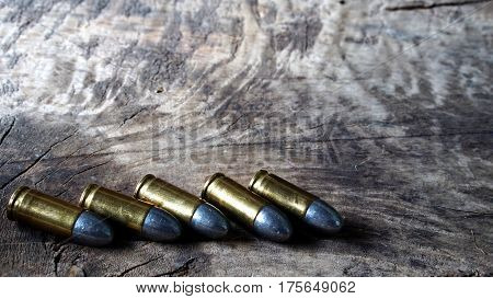 Bullets and a firearm on the wood. Bullets are a projectile expelled from the barrel of a firearm.