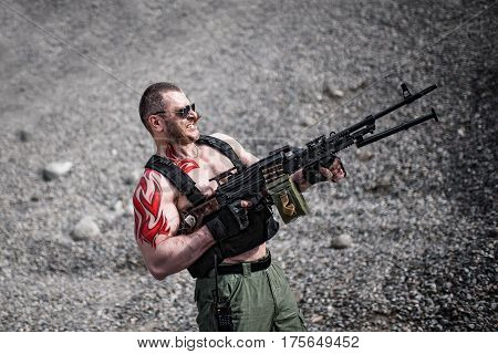 Strong soldier with a machine gun and a cigar