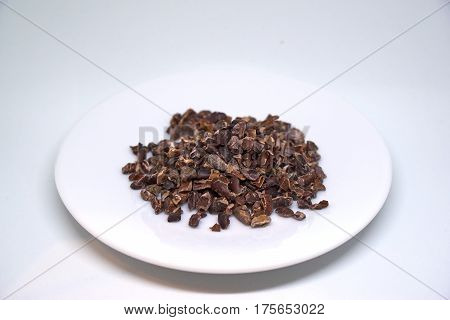 cacao nibs on a plate isolated on white background