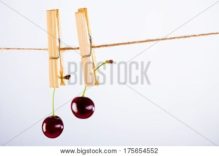 Red Cherry and rope on white with clamp fruit concept - desert, food