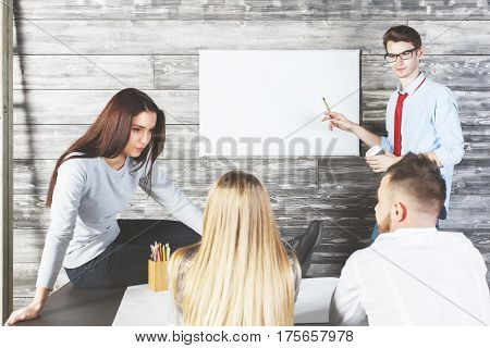 Handsome european man showing empty whiteboard with copy space to team. Presentation and meeting concept