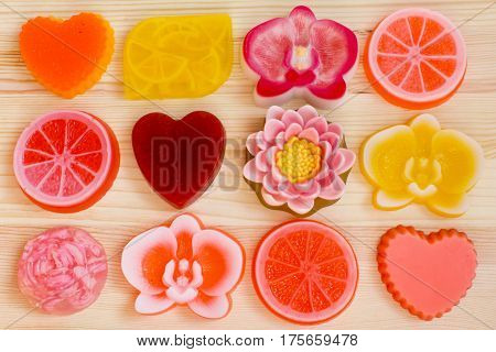 Different types of the exclusive organic handmade soaps. Rose lotus orchid heart orange lemon on the wooden background.