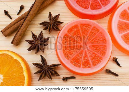 Original handmade soap shaped like orange. Fresh orange anise cinnamon and cloves on the background.