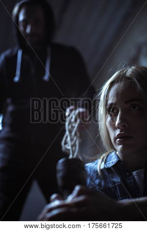 Just turn around. Evil hateful brutal criminal standing behind a girl with a rope in his hand wanting taking her hostage