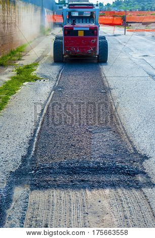 excavator perform milling of asphalt and aspiration of debris. Process that produces a lot of dust