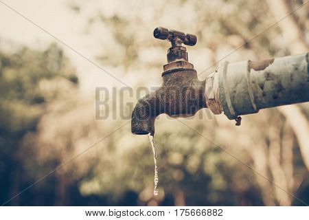A faucet with a water drop / Water consumption and shortage concept