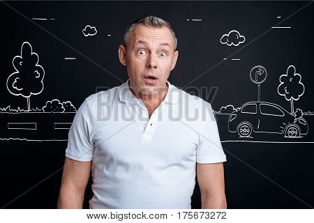 How can it happen. Astonished adult man standing near the road and feeling destressed while witnessing car crash