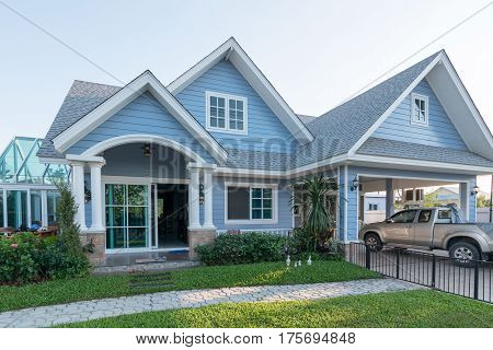 Bright Blue House In Sunlght With Colorful Poppies And Some Graceful Trees