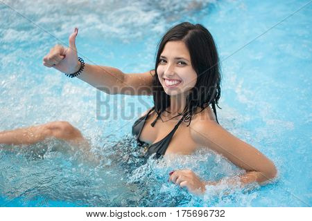 Close-up Portrait Of Smiling Girl Enjoying In Jacuzzi And Showing Thumb Up Gesture Of Good Class In
