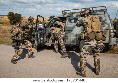Squad of elite french paratroopers of 1st Marine Infantry Parachute Regiment RPIMA detaining terrorist in the car