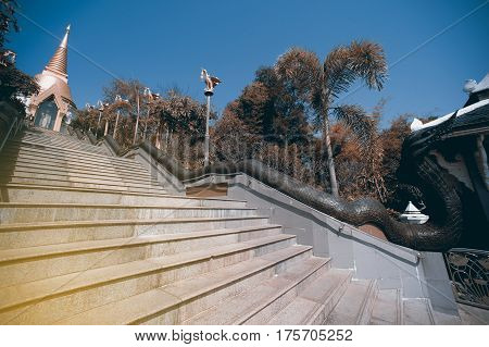 UDON THANI,THAILAND - JAN 25,2014:The Chedi Prathom Rattanamahaburaphachan above the steep staircase.The Chedi in Sri Lanka style, richly adorned with small golden mosaic stones,marble and granite ,in Wat Pa Phu Kon of Ban Na Kham,Na yung District in Udon