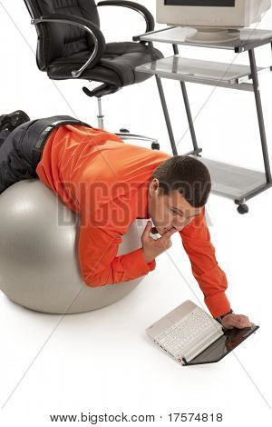 Jeune entrepreneur faisant gim avec ballon gris, à la recherche sur l'écran du portable.