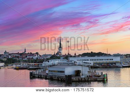 Evening panorama of Tallinn at sunset. View from ferry on sea terminal passenger port and old town architecture with high spire on Church of St. Olaf. Baltic States Estonia Old City Harbor
