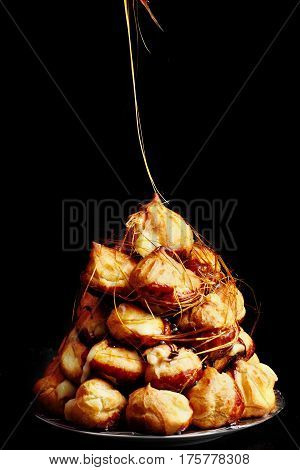 Cake Profiteroles With Caramel On Black Background.selective Focus. Flying Caramel