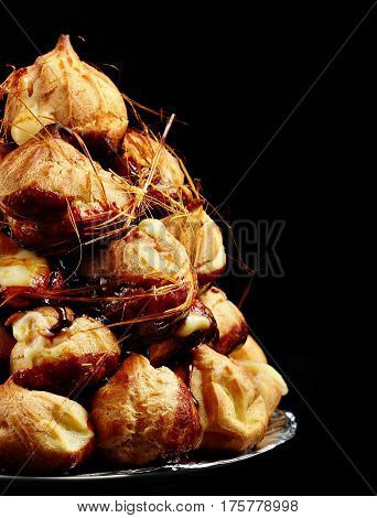 Cake Profiteroles With Caramel On Black Background.selective Focus. Copy Space