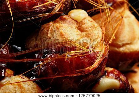 Cake Profiteroles With Caramel On Black Background.closeup.selective Focus