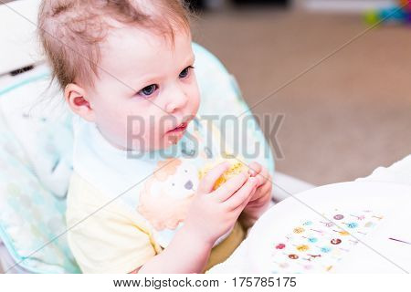 Cute toddler girl wating lunch in her high chair.