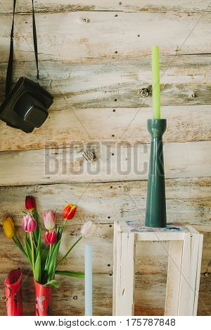 wooden background with candles flowers and camera