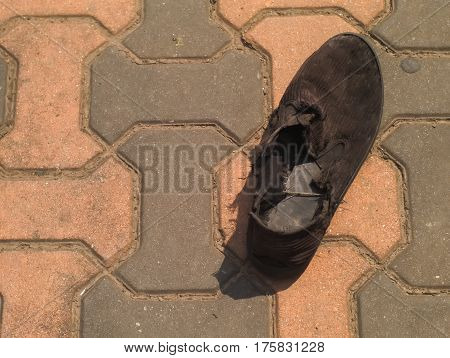 black old and wornout shoe on brick floor