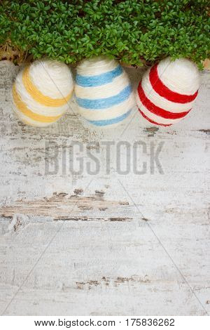 Easter Eggs Wrapped Woolen String And Green Cress On Wooden Background, Copy Space For Text, Decorat