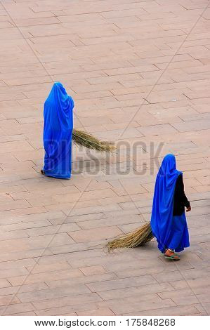 Women sweeping Jaleb Chowk - main courtyard of Amber Fort Rajasthan India. Amber Fort is the main tourist attraction in the Jaipur area.