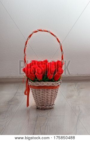spring pink rose flowers in basket on wooden background.