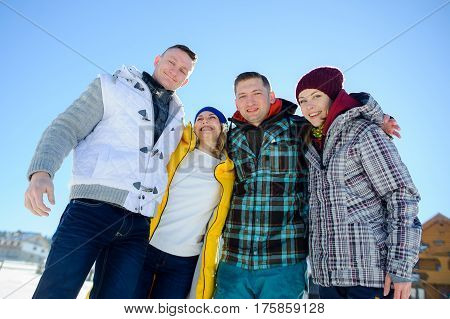 Cheerful group of friends posing for the camera. Two young men and two girl. All good mood. Friends are hugging and laughing merrily.