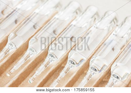Row of transparent medical ampules in package. Close up