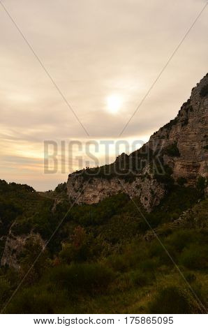 Sea cliffs with the sun setting over the Amalfi Coast in Italy.