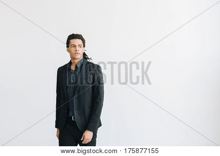 Happy young businessman in black suite and blue shirt standing over white background. Portrait of a handsome  boy. Color