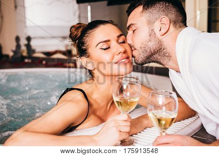 Beautiful Young Couple Relaxing Together And Drinking White Wine In Spa