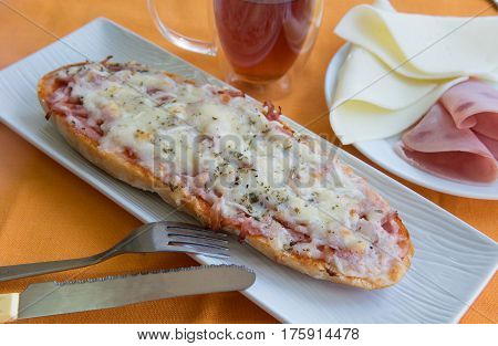 Bread pizza with ham and cheese and dark tea