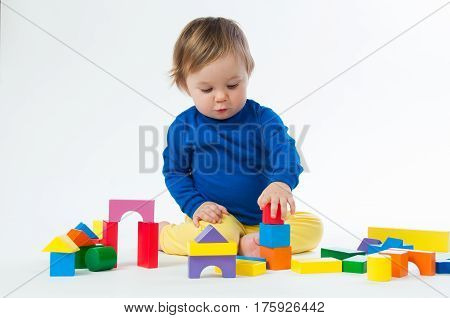 Little child playing with dices isolated on white background.