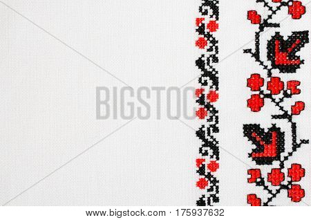 Texture of White Canvas With Slavic Red and Black Embroidery by Cross-stitch. Ukrainian Embroidery for Background.
